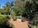 Outdoor brick fire pit surrounded by six chairs in a lush tropical backyard at 2647 Zuni Rd, St Cloud, FL 34771