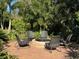 Outdoor brick fire pit surrounded by six chairs in a lush tropical backyard at 2647 Zuni Rd, St Cloud, FL 34771
