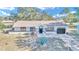 Single-story house with a gray exterior, black door, and landscaped yard at 37 Hickory Track Way, Ocala, FL 34472