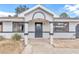 Modern front entrance with gray door, white columns, and stone flooring at 37 Hickory Track Way, Ocala, FL 34472