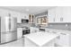 Modern kitchen with white cabinets, stainless steel appliances, and gray tile backsplash at 37 Hickory Track Way, Ocala, FL 34472