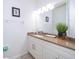 Clean bathroom with granite countertop, white cabinets, and large mirror at 4706 Vero Beach Pl, Kissimmee, FL 34746