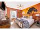 King-size bed in a spacious bedroom with a unique wall mural at 4706 Vero Beach Pl, Kissimmee, FL 34746