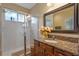 Bathroom with shower, granite vanity, and large mirror at 8426 Chamberlain Pl, Oviedo, FL 32765
