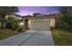 House exterior featuring a two-car garage and manicured lawn at 10952 Arbor View Blvd, Orlando, FL 32825