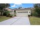 House exterior featuring a two-car garage and manicured lawn at 10952 Arbor View Blvd, Orlando, FL 32825