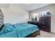 Bedroom with teal bedding, dark brown dresser, and window blinds at 1108 Evangeline Ave, Orlando, FL 32809
