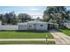 Single-story home with gray exterior, white fence, and carport at 1108 Evangeline Ave, Orlando, FL 32809