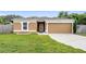 One-story house with a two-car garage and landscaped lawn at 1208 Honey Rd, Apopka, FL 32712