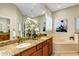 Elegant bathroom with granite countertops, a corner tub, and a walk-in shower at 13607 Zori Ln, Windermere, FL 34786