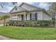 Side view of a single-story house with manicured hedges and a well-maintained lawn at 13607 Zori Ln, Windermere, FL 34786