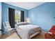 Blue bedroom with a queen-size bed and large window at 142 Santana Pl, Davenport, FL 33897