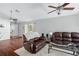 Living room with hardwood floors, brown leather couches and ceiling fan at 142 Santana Pl, Davenport, FL 33897