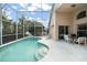 Inviting pool area with screened enclosure, patio furniture, and basketball hoop at 142 Santana Pl, Davenport, FL 33897