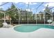 Relaxing kidney-shaped pool with screened enclosure and patio furniture at 142 Santana Pl, Davenport, FL 33897