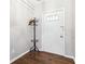 Front entry with dark hardwood floor, coat rack, and white door at 1429 Royal Palm Dr, Edgewater, FL 32132