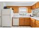 Kitchen features wood cabinets, white appliances, and a built-in dishwasher at 1429 Royal Palm Dr, Edgewater, FL 32132