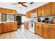Open kitchen boasts wood cabinets, ample counter space, and a ceiling fan at 1429 Royal Palm Dr, Edgewater, FL 32132