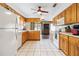 Open kitchen with wood cabinets, view to living area, and tile flooring at 1429 Royal Palm Dr, Edgewater, FL 32132
