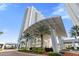 Modern high-rise building with covered parking and landscaping at 241 Riverside Drive # 409, Daytona Beach, FL 32117
