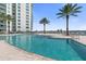 Relaxing pool area with palm trees and a view of the water at 241 Riverside Drive # 409, Daytona Beach, FL 32117