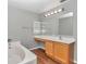 Bathroom with double vanity, wood-look flooring, and a large mirror at 2718 Se 45Th Ave, Ocala, FL 34480