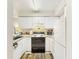 Galley kitchen with white cabinets and appliances at 273 Scottsdale Sq # 273, Winter Park, FL 32792