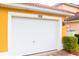 White garage door with number 308 on a yellow house at 308 Robin Rd, Davenport, FL 33896