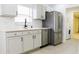 Modern kitchen with gray cabinets, stainless steel appliances, and laundry area at 308 Robin Rd, Davenport, FL 33896