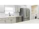 Modern kitchen with gray cabinets, stainless steel appliances, and laundry area at 308 Robin Rd, Davenport, FL 33896