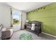 Charming Bedroom with a crib and leafy green accent wall at 3326 Private Oak Dr, Apopka, FL 32703