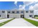 Modern townhome exterior with two-car garage and landscaped lawn at 3332 Private Oak Dr, Apopka, FL 32703