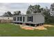 Gray manufactured home with black shutters and a spacious yard at 3548 Valley Trl, Lakeland, FL 33810