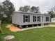 Gray manufactured home with black shutters and a grassy lawn at 3548 Valley Trl, Lakeland, FL 33810