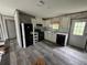 Simple kitchen with white cabinets, black appliances, and wood-look floors at 3548 Valley Trl, Lakeland, FL 33810