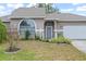 Gray siding, arched window, and gray door. Landscaped front yard at 430 Magpie Ct, Kissimmee, FL 34759