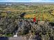 Aerial view showing property location nestled among lush trees near a road at 4390 Saxon Dr, New Smyrna Beach, FL 32169