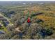 Aerial view showing property location nestled among lush trees near a road at 4390 Saxon Dr, New Smyrna Beach, FL 32169