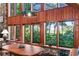 Dining area with wood table and chairs, large windows with nature views at 4390 Saxon Dr, New Smyrna Beach, FL 32169