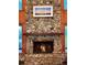 Rustic stone fireplace with wood mantle and burning fire at 4390 Saxon Dr, New Smyrna Beach, FL 32169