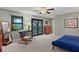 Main bedroom with a king-size bed, rocking chair and balcony access at 4390 Saxon Dr, New Smyrna Beach, FL 32169