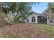 Spacious backyard with mature trees and a partially covered patio at 440 Macgregor Rd, Winter Springs, FL 32708