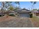 House exterior showcasing a gray garage door and landscaped yard at 440 Macgregor Rd, Winter Springs, FL 32708
