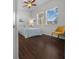 Bright bedroom with a double bed, dark wood floors, and a yellow chair at 5106 Nw 35Th Lane Rd, Ocala, FL 34482