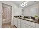 Bathroom with double vanity, granite countertop, and tub shower combo at 5437 Misty Oak Cir, Davenport, FL 33837