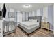 Main bedroom with gray upholstered bed and crib at 5437 Misty Oak Cir, Davenport, FL 33837