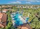 Aerial view of resort-style community pool with lounge chairs and palm trees at 5437 Misty Oak Cir, Davenport, FL 33837