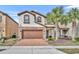 Two-story house with brown brick driveway and garage at 5437 Misty Oak Cir, Davenport, FL 33837