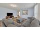 Living room with gray sectional sofa and wood-look floors at 5437 Misty Oak Cir, Davenport, FL 33837