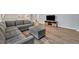 Living area showcasing a gray sectional and ottoman, wood-look floors at 5437 Misty Oak Cir, Davenport, FL 33837